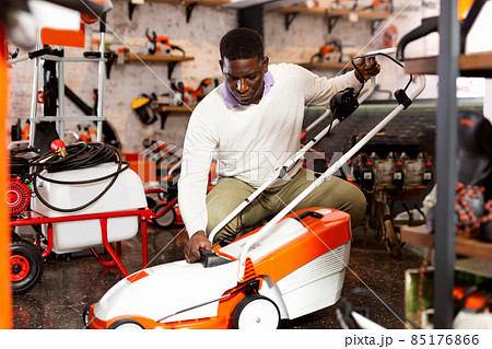 Man choosing grass-mower in gardening tools store Man choosing grass-mower in gardening tools store 85176866