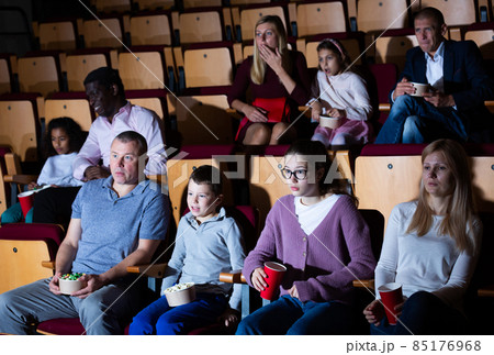 caucasian family sitting at scary premiere in cinema 85176968