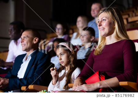 parents with children laughting at movie in cinema 85176982
