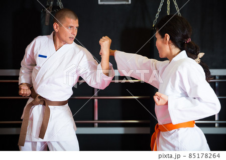 Man and woman sparring during karate training Man and woman sparring during karate training 85178264