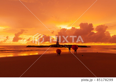 Tourists open umbrellas to watch Beautiful scenery at sunset Tourists open umbrellas to watch Beautiful scenery at sunset 85178299