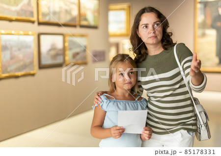 Girl with woman in masks looking with interest at painting 85178331