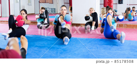 Sporty women are sitting on the floor and doing exercise in box gym. 85178508