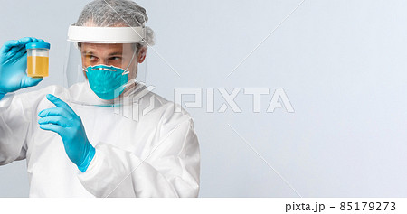 Covid-19, preventing virus, healthcare workers and vaccination concept. Medical employee, nurse or doctor in personal protective equipment examine urine sample of patient Covid-19, preventing virus, healthcare workers and vaccination concept. Medical employee, nurse or doctor in personal protective equipment examine urine sample of patient 85179273