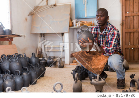 Potter checking quality of ceramic objects 85179730