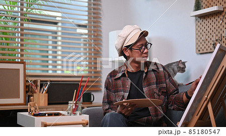 Male artist working on painting in his art studio. 85180547