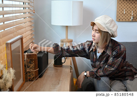 Young woman adjusting and control the volume on the speaker. 85180548