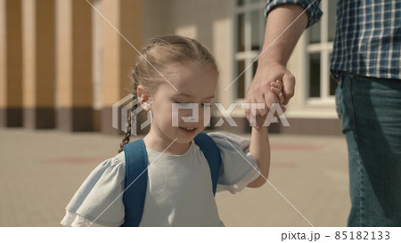Dad leads the child by hand to school, close-up, a little schoolgirl with backpack, a happy family, a kid's childhood dream, an active student girl, good modern education, love and receive knowledge 85182133