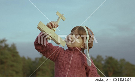 little child in a helmet plays with an airplane against sky, childhood dream to fly, kid wants to become an airplane pilot, imagination, happy family, cheerful baby makes illusion flight in fantasies little child in a helmet plays with an airplane against sky, childhood dream to fly, kid wants to become an airplane pilot, imagination, happy family, cheerful baby makes illusion flight in fantasies 85182134
