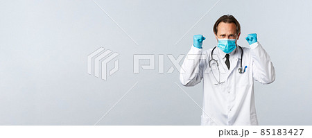 Covid-19, preventing virus, healthcare workers and vaccination concept. Determined doctor get ready, boost confident before enter clinic with sick patients, raise clenched fists, wear mask and gloves Covid-19, preventing virus, healthcare workers and vaccination concept. Determined doctor get ready, boost confident before enter clinic with sick patients, raise clenched fists, wear mask and gloves 85183427