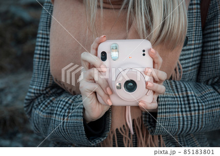 Woman hands holding a pink instax camera Woman hands holding a pink instax camera 85183801