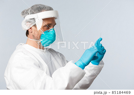 Covid-19, preventing virus, healthcare workers and vaccination concept. Profile shot of doctor in personal protective equipment fill syringe with coronavirus vaccine, treating sick patient 85184469