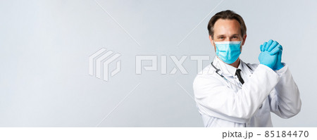 Covid-19, preventing virus, healthcare workers and vaccination concept. Encouraged and determined optimistic doctor in medical mask and gloves, clench hands together in victory 85184470