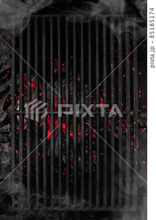 Top view of smouldering charcoals under black cast iron grill grate 85185174