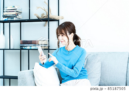 リビングのソファーでスマホを使う女性 リビングのソファーでスマホを使う女性 85187505
