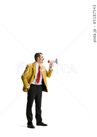 Full-length portrait of man in a suit, worker shouting into megaphone isolated over white background. 85187543