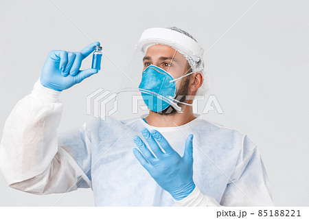 Covid-19 pandemic, virus outbreak, clinic and healthcare workers concept. Excited pationate male doctor researcher in lab clinic, wear personal protective equipment, develop coronavirus vaccine 85188221