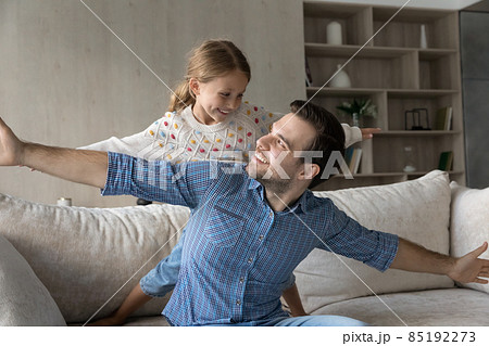 Happy small girl playing with father at home. Happy small girl playing with father at home. 85192273