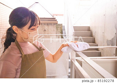 マンションの共用部を雑巾で拭き掃除する若い女性 85192278