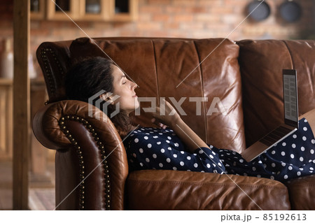 Relaxed happy young hispanic woman reading book on computer. Relaxed happy young hispanic woman reading book on computer. 85192613