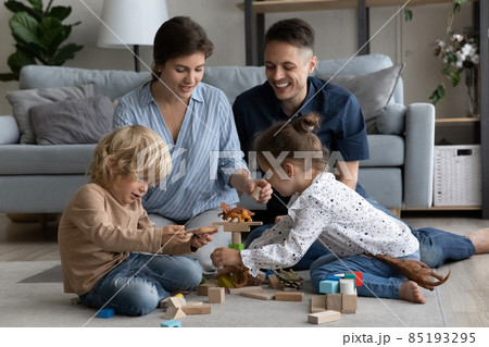 Happy mom, dad and little siblings playing with toys together Happy mom, dad and little siblings playing with toys together 85193295