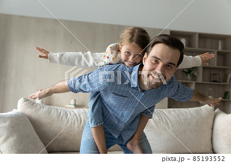 Happy caring young father holding on back joyful daughter. 85193552