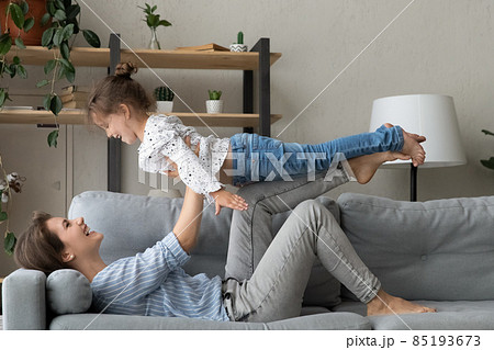 Happy mom lifting little daughter kid up in air Happy mom lifting little daughter kid up in air 85193673