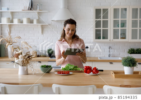 Happy millennial young woman cooking dinner in home kitchen 85194335