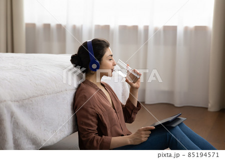 Relaxed young indian woman drinking glass of water. 85194571