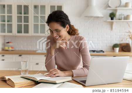 Smiling woman in glasses studying at home, reading book 85194594