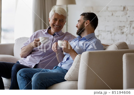 Happy two generations family enjoying talking, drinking coffee. 85194606