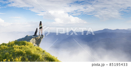 Adventurous Woman Hiking on top of a mountain with a Husky dog Adventurous Woman Hiking on top of a mountain with a Husky dog 85195433