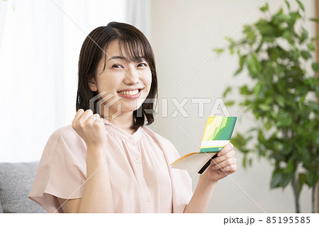 預金通帳を見てガッツポーズをする女性 預金通帳を見てガッツポーズをする女性 85195585