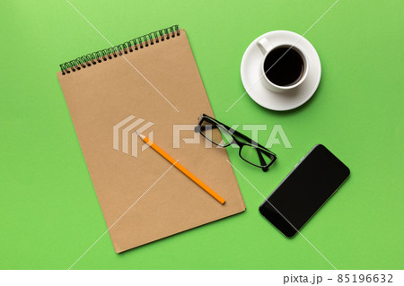 Modern office desk table with notebook, smartphone and other supplies with cup of coffee. Blank notebook page for you design. Top view, flat lay Modern office desk table with notebook, smartphone and other supplies with cup of coffee. Blank notebook page for you design. Top view, flat lay 85196632