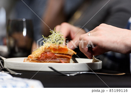 Man eating Francesinha, traditional Portuguese sandwich in a restaurant. National cuisine concept 85199116
