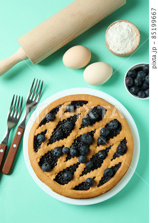 Concept of cooking blueberry pie on mint background Concept of cooking blueberry pie on mint background 85199667
