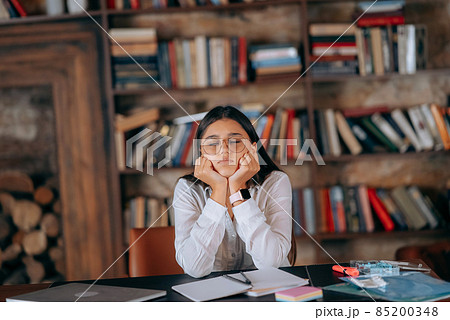 Young woman in office thinking over problem on background of bookshelves 85200348