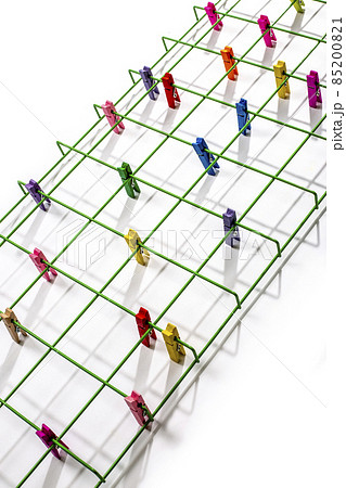 Still life with green metal lattice and multi-colored clothespins 85200821