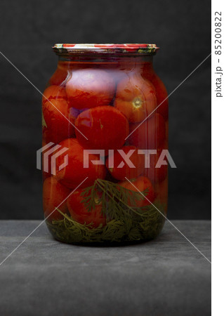 Glass jar with canned tomatoes on the table Glass jar with canned tomatoes on the table 85200822