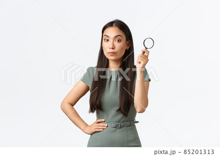 Small business owners, women entrepreneurs concept. Asian female searching for something, holding magnifying glass and looking at camera suspicious, gonna find the truth, white background Small business owners, women entrepreneurs concept. Asian female searching for something, holding magnifying glass and looking at camera suspicious, gonna find the truth, white background 85201313