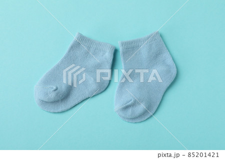 Pair of cute baby socks on blue background Pair of cute baby socks on blue background 85201421