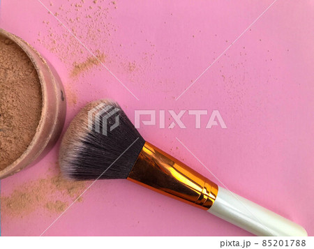 powder on a pink background. brush for applying powder on the face, cheeks, forehead. makeup artist tool, tube beauty. mineral powder, matte powder on a pink background. brush for applying powder on the face, cheeks, forehead. makeup artist tool, tube beauty. mineral powder, matte 85201788