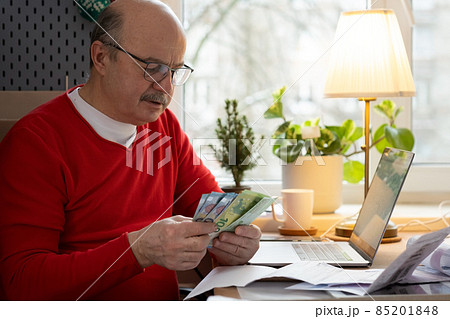Senior man with eyeglasses counting money from retirement and control finance Senior man with eyeglasses counting money from retirement and control finance 85201848