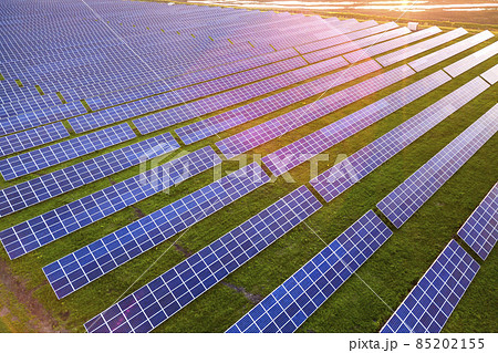 Blue solar photo voltaic panels system producing renewable clean energy on rural landscape and setting sun background. Blue solar photo voltaic panels system producing renewable clean energy on rural landscape and setting sun background. 85202155