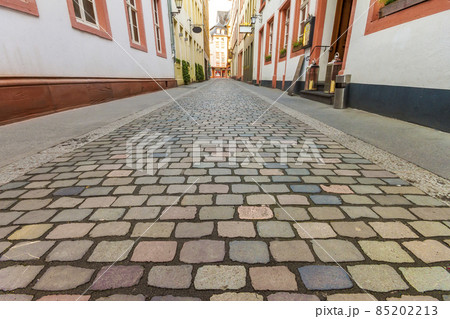 Beautiful view of scenic narrow street with historic traditional houses and cobbled street in an old town in Europe with blue sky and clouds in summer 85202213
