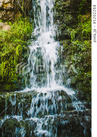 Motion blur. Waterfall in the mountains. Water splashes. Long exposure, selective focus. Motion blur. Waterfall in the mountains. Water splashes. Long exposure, selective focus. 85202268