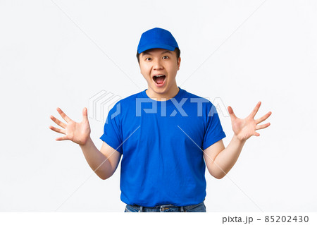 Portrait of excited and euphoric asian delivery man in blue uniform react to wonderful news, shaking hands happy and thrilled, telling big announcement, rejoicing over white background Portrait of excited and euphoric asian delivery man in blue uniform react to wonderful news, shaking hands happy and thrilled, telling big announcement, rejoicing over white background 85202430