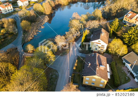 Aerial view of residential houses with red roofs and streets with parked cars in rural town area. Quiet suburbs of a modern european city. Aerial view of residential houses with red roofs and streets with parked cars in rural town area. Quiet suburbs of a modern european city. 85202580