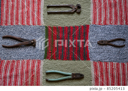 old and rusty tools on a multi-colored knitted tablecloth 85205413