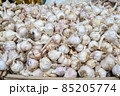 Fresh garlic for sale at vegetable market, close up. Boxes full of raw garlic in shop. Organic garlic at the greengrocer's stall. Vegetable. 85205774